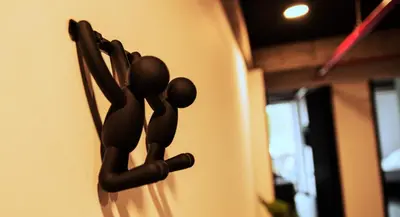 a black statue of two people hanging on a wall at The Coffee Club Apartahotel in Manizales