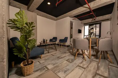 a living room with a table and chairs and a potted plant at The Coffee Club Apartahotel in Manizales
