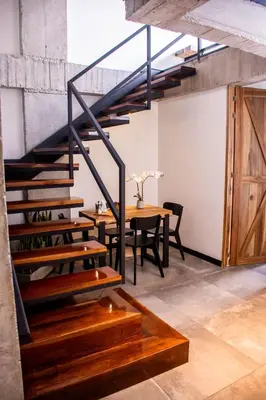 a staircase in a room with a table and a dining room at The Coffee Club Apartahotel in Manizales