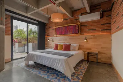 a bedroom with a bed and a wooden wall at Masaya Medellin in Medellín