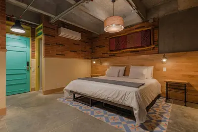 a bedroom with a bed and a blue door at Masaya Medellin in Medellín