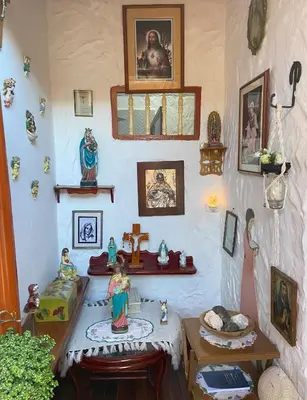 a room with a table with figurines and pictures on the wall at Casa Patrimonial Abejorral - CASA GASAMA in Abejorral