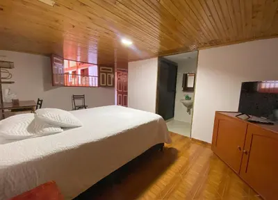 a bedroom with a large bed and a television at Casa Patrimonial Abejorral - CASA GASAMA in Abejorral