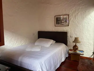 a bedroom with a white bed and a table with a lamp at Casa Patrimonial Abejorral - CASA GASAMA in Abejorral