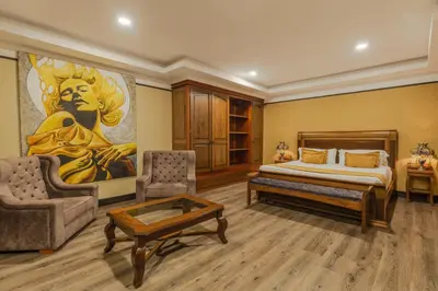a bedroom with a king sized bed and a painting at Hotel Du Parc in Medellín