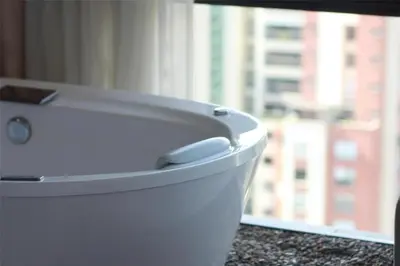 a white toilet sitting on a counter next to a window at York Medellin, Curio Collection by Hilton in Medellín