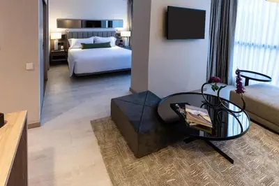 a living room with a bed and a table in a room at York Medellin, Curio Collection by Hilton in Medellín