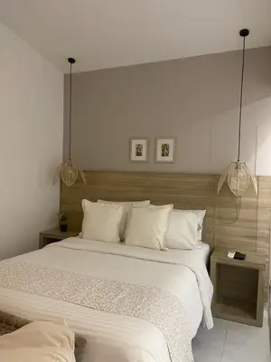 a bedroom with a large bed with white sheets at Moet Medellin Hotel in Medellín