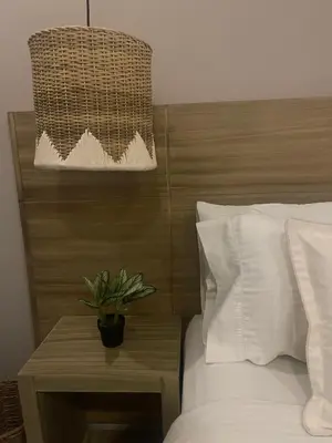 a bedroom with a bed with a wooden headboard and a potted plant at Moet Medellin Hotel in Medellín