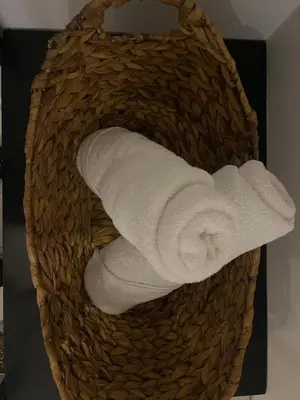 a basket filled with white towels in a bathroom at Moet Medellin Hotel in Medellín