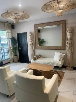 a living room with a table and chairs and a mirror at Moet Medellin Hotel in Medellín