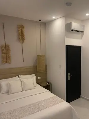 a bedroom with a large bed with white pillows at Moet Medellin Hotel in Medellín