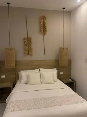 a bedroom with a white bed with two baskets on the wall at Moet Medellin Hotel in Medellín