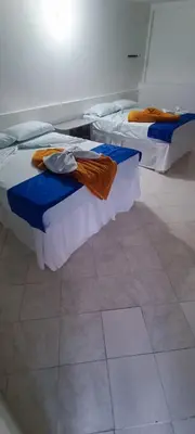 two beds in a room with blue and white at HOTEL BRISAS DE SANTA FE in Santa Fe de Antioquia