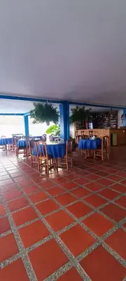 a restaurant with tables and chairs and a view of the ocean at HOTEL BRISAS DE SANTA FE in Santa Fe de Antioquia
