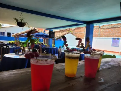 a group of three drinks sitting on a wooden table at HOTEL BRISAS DE SANTA FE in Santa Fe de Antioquia