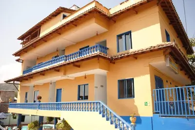 a large house with blue balconies on the side of it at HOTEL BRISAS DE SANTA FE in Santa Fe de Antioquia