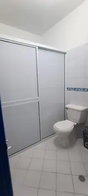 a bathroom with a toilet and glass doors at HOTEL BRISAS DE SANTA FE in Santa Fe de Antioquia