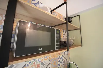 a microwave on a shelf in a kitchen at Alojamiento en apartamento cerca a Provenza - M203 By Roots Rentals in Medellín