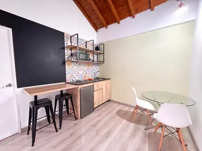 a kitchen with a table and chairs in a room at Alojamiento en apartamento cerca a Provenza - M203 By Roots Rentals in Medellín