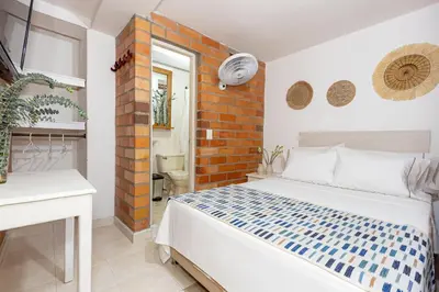 a bedroom with a bed and a brick wall at Gran Caribe Hotel in Medellín