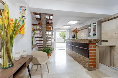 a large kitchen with a counter and chairs at Gran Caribe Hotel in Medellín