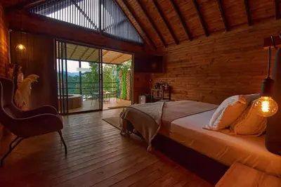 a bedroom with a bed and a large window at Mumu by Bernalo Hotels in Guatapé