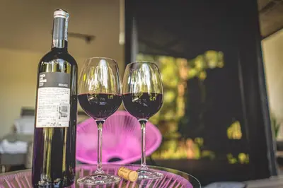 two wine glasses sitting on a table with a bottle of wine at Mumu by Bernalo Hotels in Guatapé