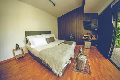 a bedroom with a large bed and a tv at Mumu by Bernalo Hotels in Guatapé