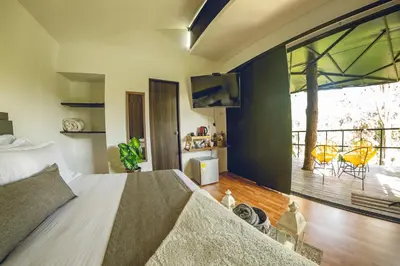a bedroom with a large bed and a large window at Mumu by Bernalo Hotels in Guatapé