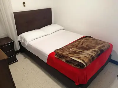 a bed in a room with a red and white bed sidx sidx sidx at HOTEL MI CASA DEL NORTE in Santa Rosa de Osos