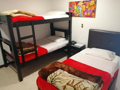 a room with two bunk beds and a chair at HOTEL MI CASA DEL NORTE in Santa Rosa de Osos