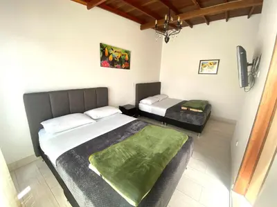 a bedroom with two beds and a tv in it at HOTEL MI CASA DEL NORTE in Santa Rosa de Osos