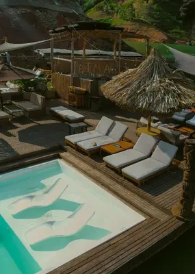 a swimming pool with lounge chairs and an umbrella at Atma Villas - Holistic Wellness Experience in Guatapé