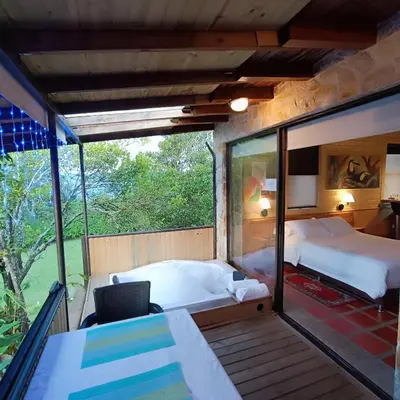 a room with two beds and a desk and a window at CABAÑAS MONTEVERDE - Guarne ANT in Guarne
