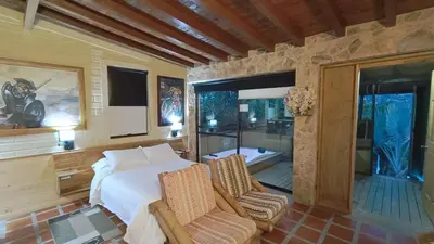 a bedroom with a large bed and two chairs at CABAÑAS MONTEVERDE - Guarne ANT in Guarne