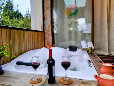 a bottle of wine and two glasses on a table at CABAÑAS MONTEVERDE - Guarne ANT in Guarne