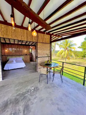a room with a bed and a table and chairs at Finca en Doradal ( Hacienda Napoles y Rio Claro ) in Doradal
