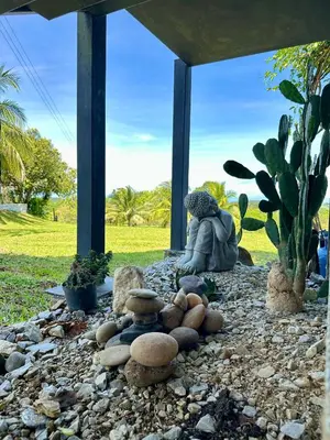 a rock garden with a woman sitting on the ground at Finca en Doradal ( Hacienda Napoles y Rio Claro ) in Doradal