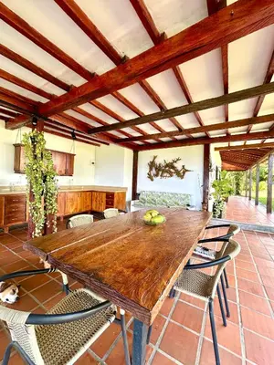 a dining room with a wooden table and chairs at Finca en Doradal ( Hacienda Napoles y Rio Claro ) in Doradal