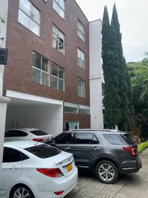 two cars parked in front of a building at Hotel Boutique las Rosas 5 G in Medellín