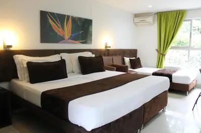 a hotel room with two beds and a couch at Hotel Boutique las Rosas 5 G in Medellín