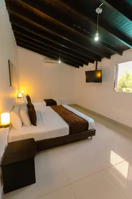 a bedroom with a bed with two cats sitting on it at Hotel Boutique las Rosas 5 G in Medellín