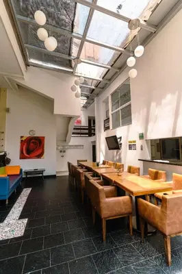 a conference room with wooden tables and chairs at Hotel Boutique las Rosas 5 G in Medellín
