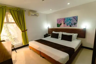 a bedroom with a bed and a painting on the wall at Hotel Boutique las Rosas 5 G in Medellín