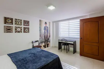 a bedroom with a bed and a table and a window at Disfruta de la comodidad como un Hotel 5 Estrellas in Envigado