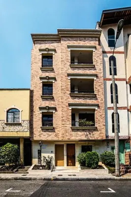 a tall brick building with windows on a street at Disfruta de la comodidad como un Hotel 5 Estrellas in Envigado