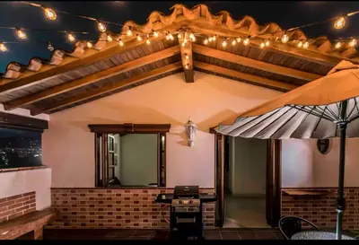a patio with a table and an umbrella and lights at Disfruta de la comodidad como un Hotel 5 Estrellas in Envigado