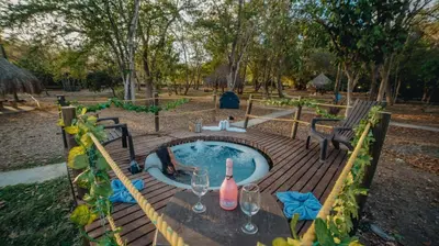a table with a bottle of wine and wine glasses at La Ardilla de Santa Fe by Bernalo Hotels in Santa Fe de Antioquia