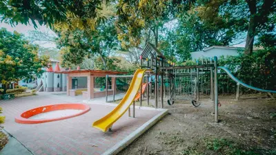 a playground with a yellow slide in a park at La Ardilla de Santa Fe by Bernalo Hotels in Santa Fe de Antioquia